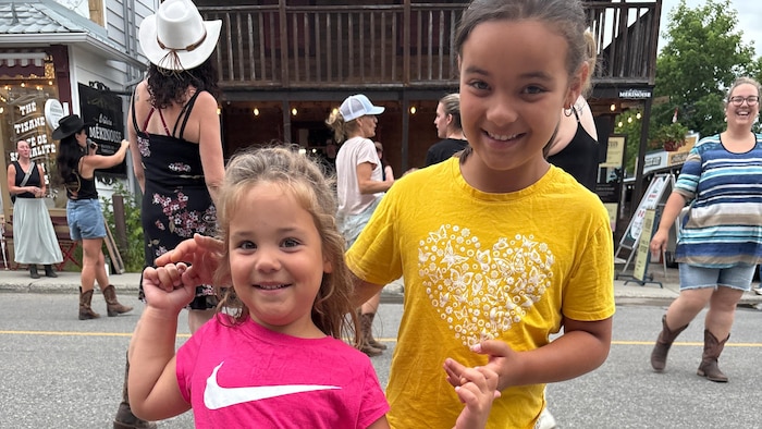 Portrait de Jade et Sophie Noël, tout sourire, avec leurs bottes de cowgirls.