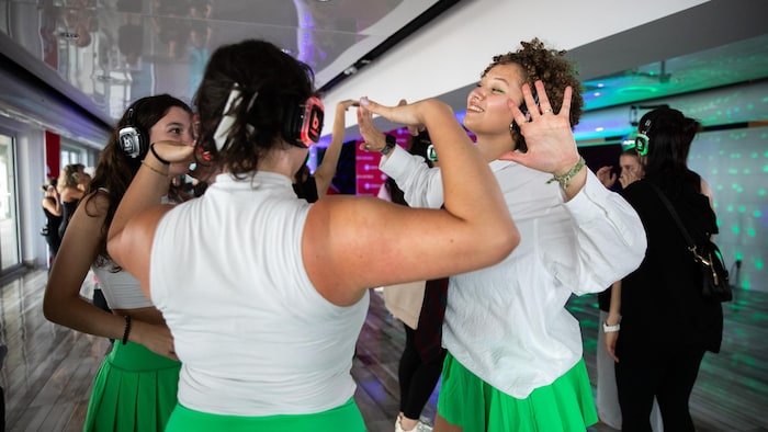 Des filles dansent avec des écouteurs.