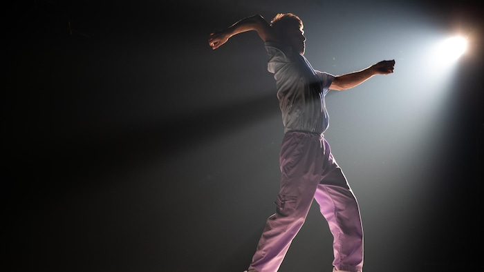 Un danseur sur une scène fait une prestation.