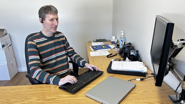Un homme tape sur son clavier d'ordinateur.