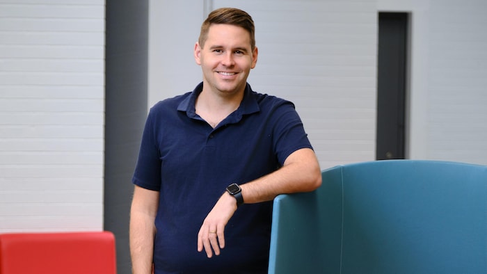 Le directeur général du Cégep de l'Abitibi-Témiscamingue pose devant du mobilier du cégep