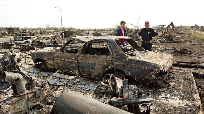 رئيس الحكومة الكندية جوستان ترودو (إلى اليسار) خلال جولة له في فورت ماكموري في أيار (مايو) 2016 تفقد خلالها الدمار والأضرار الناجمة عن حريق الغابات الهائل.