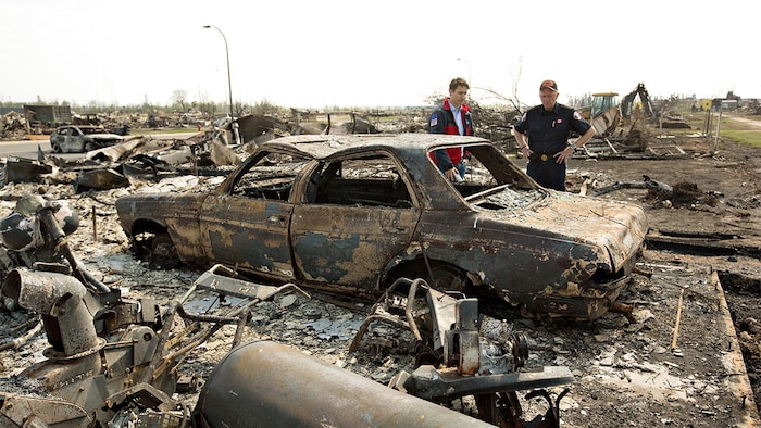 رئيس الحكومة الكندية جوستان ترودو (إلى اليسار) خلال جولة له في فورت ماكموري في أيار (مايو) 2016 تفقد خلالها الدمار والأضرار الناجمة عن حريق الغابات الهائل.