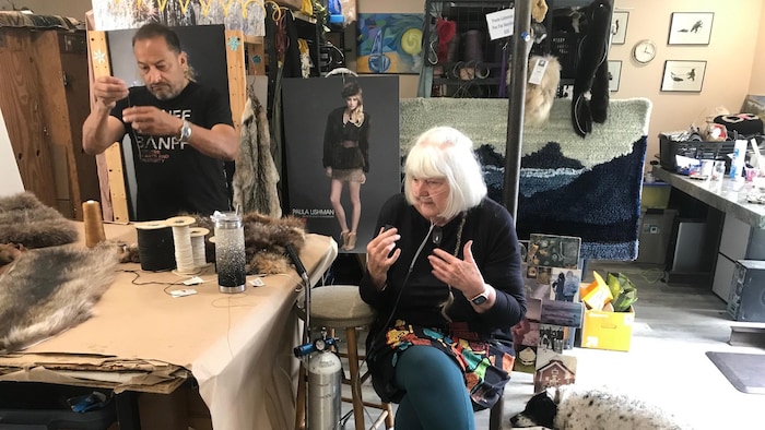 D'Arcy Moses debout avec un fil dans les mains et Paula Lishman assise à sa gauche.