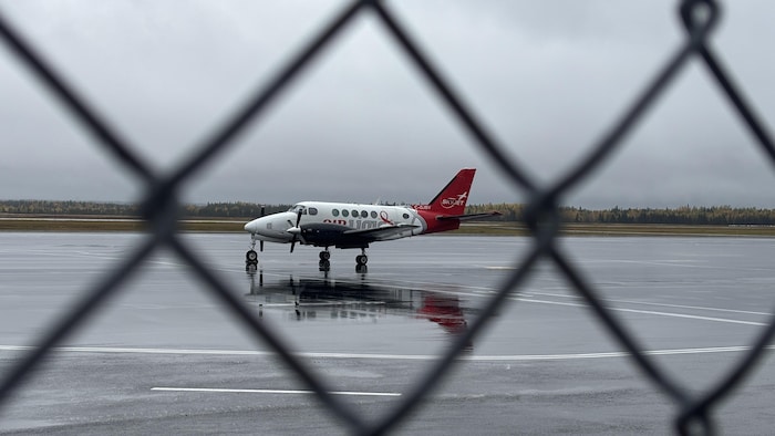 Un Dash 8 d'Air Liaison sur le tarmac lors d'une journée pluvieuse.