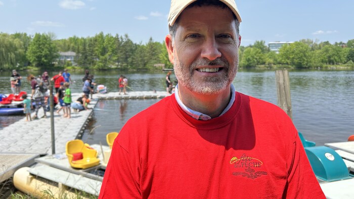 David Bouchard devant un quai rempli de jeunes pêcheurs, à la plage Lucien-Blanchard.