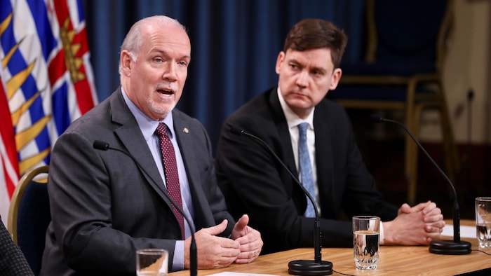John Horgan et David Eby parlent devant un micro.