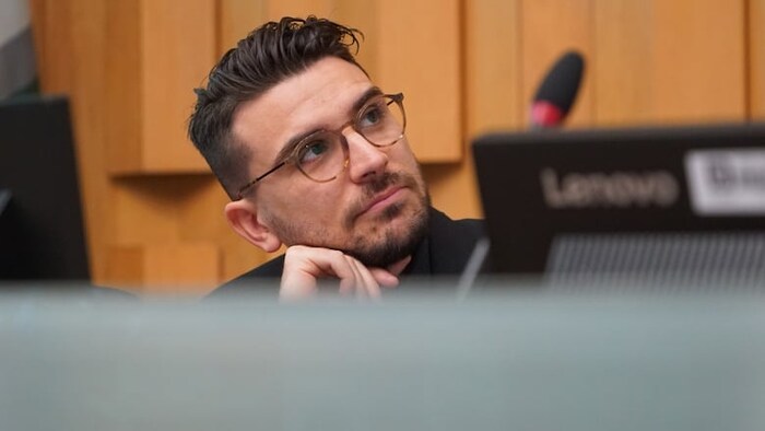 David Ferreira assis derrière la table du conseil municipal.