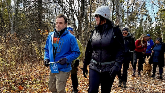 David Lauzier marche dans un sentier avec d'autres participants d'une marche