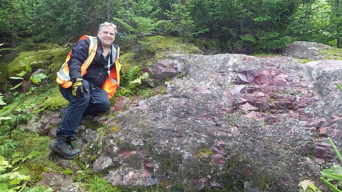 David Lentz avec une veste réfléchissante sur un rocher.