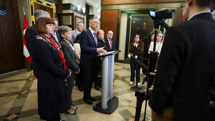 David McGuinty fait une conférence de presse, accompagné de collègues.