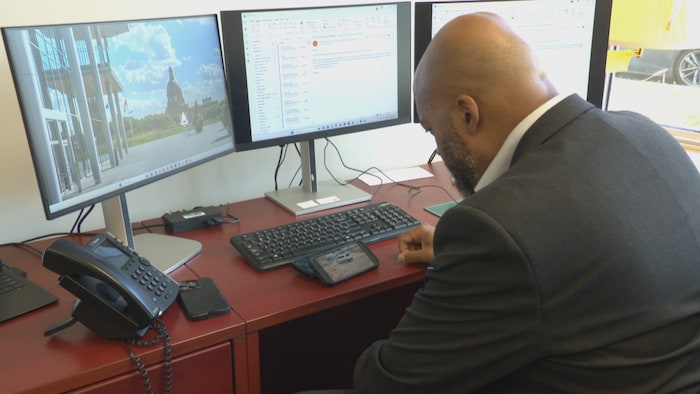 David Shepherd, porte-parole du NPD Albertain en matière de sécurité publique, regarde une vidéo sur un téléphone dans son bureau.