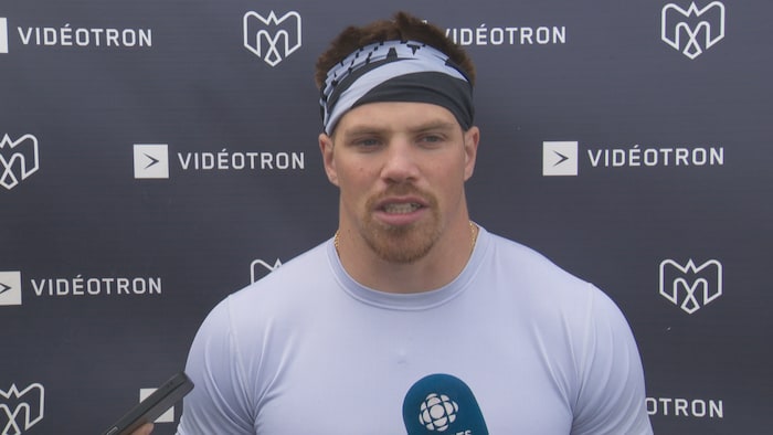 Il répond aux questions des médias après l'entraînement.