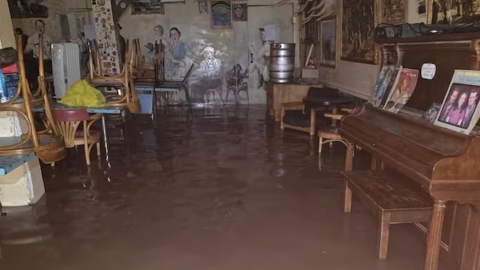De l'eau brune couvre le plancher de l'hôtel sur plusieurs centimètres de hauteur.