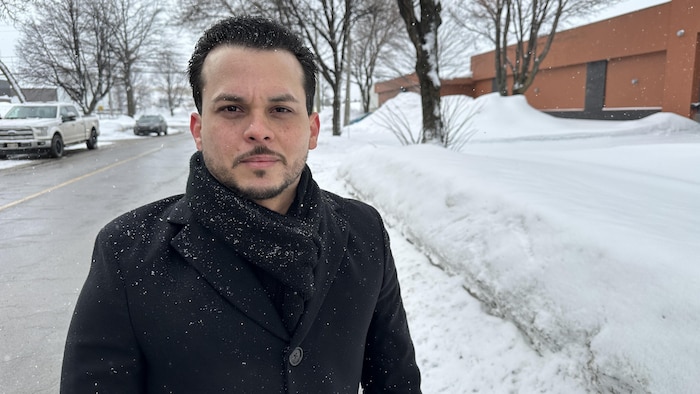 Dayron Valdez sourit pour la photo alors qu'il se tient debout dans une rue enneigée.