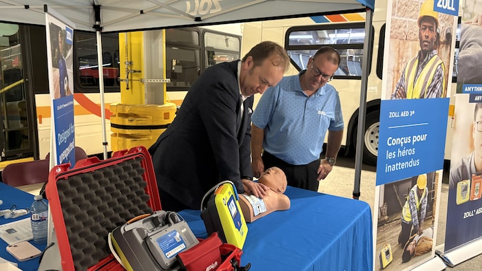 Paul Lefebvre, maire de la Ville du Grand Sudbury, essaie un des défibrillateurs externes automatisés qui seront installés dans les bus des Services de transport en commun GOVA.