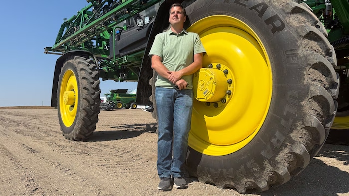 Dean Roberts se tient à l’extérieur, près d’un équipement agricole sur sa ferme de Coleville, en Saskatchewan.