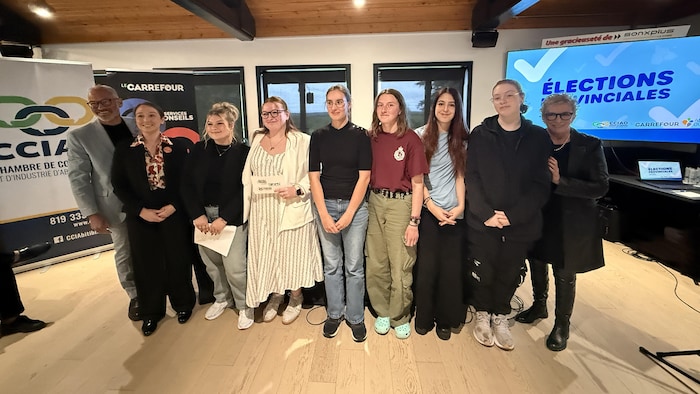 Les candidats entourent des élèves pour une photo de groupe.
