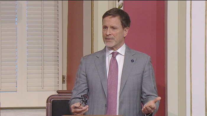 Un député parle debout au Salon rouge.