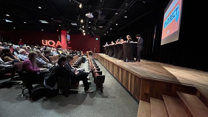 Des gens assistent à un débat.