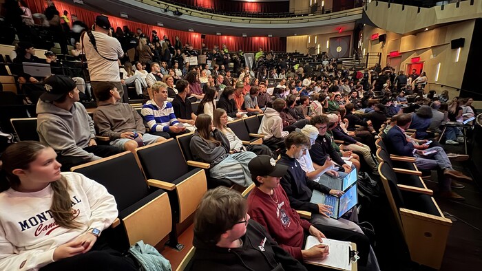 des jeunes assis dans une salle de spectacle