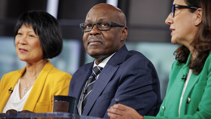 Mark Saunders assis entre Olivia Chow et Ana Bailão lors d'un débat.