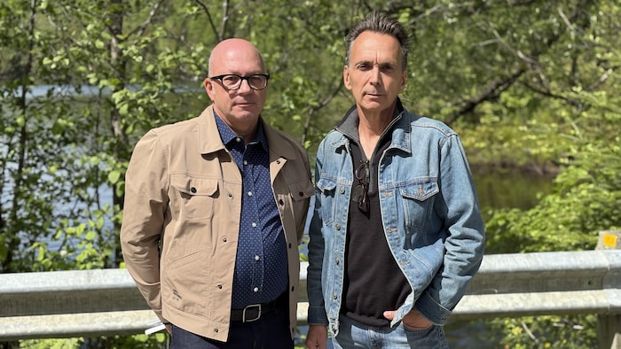 Deux hommes fixent l'objectif sérieusement. 