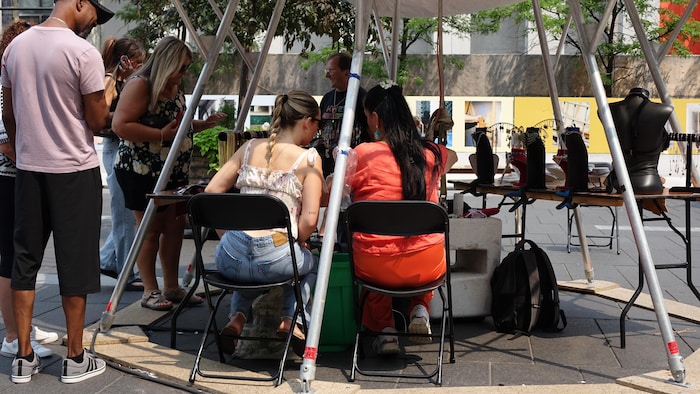 Deux femmes de dos assises à une table. 