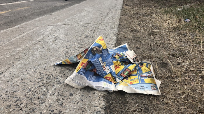 Du papier journal sur le bord d'une rue.