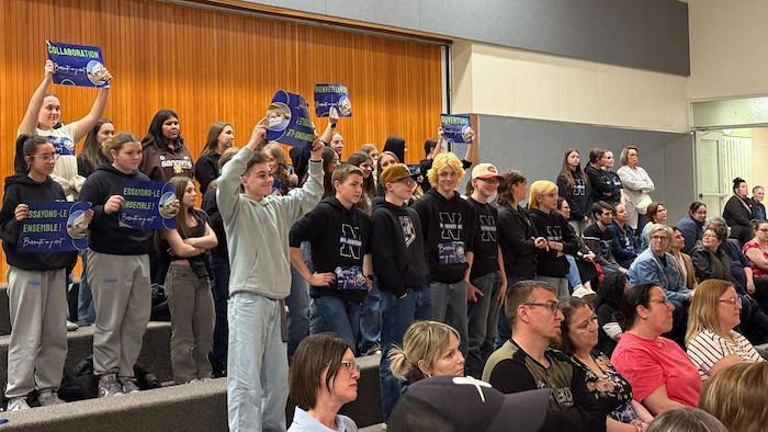 Une vingtaine d'adolescents montrent des affiches « Barraute j'y crois » et arborent les couleurs des Authentiques, nom de leurs équipes sportives.