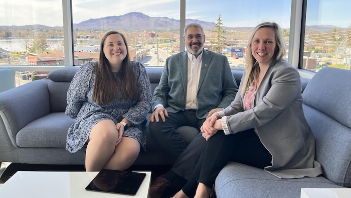 Trois personnes assises dans des fauteuils. 