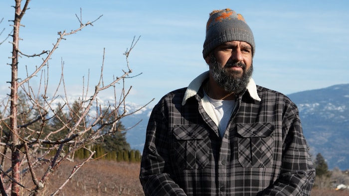 Deep Brar devant son verger en hiver, en Okanagan.