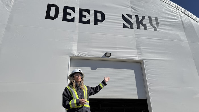 La cheffe de l’exploitation de Deep Sky, Alex Petre devant un des entrepôts de Deep Sky, à Innisfail, en Alberta, en mai 2025.