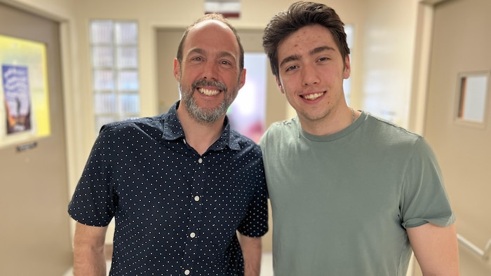 Ian Clermont debout à côté de Jérémie dans un couloir pour se faire prendre en photo. 