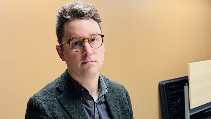Andrew Longhurst devant un document ouvert.