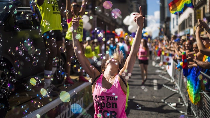 Une femme danse dans les bulles de savon au défilé de la Fierté de Toronto en 2016.