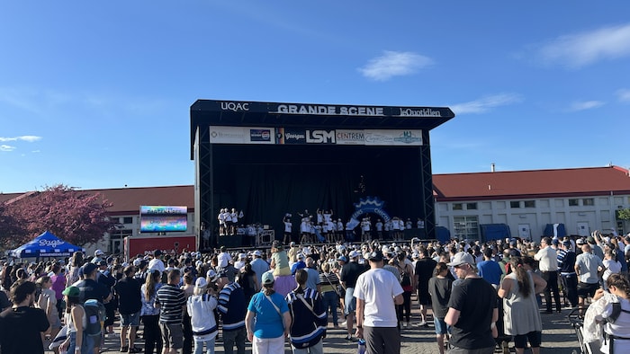 Une foule réunie devant une scène.