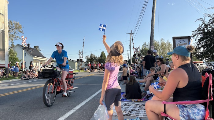 Des spectateurs assistent à un défilé de la Saint-Jean.