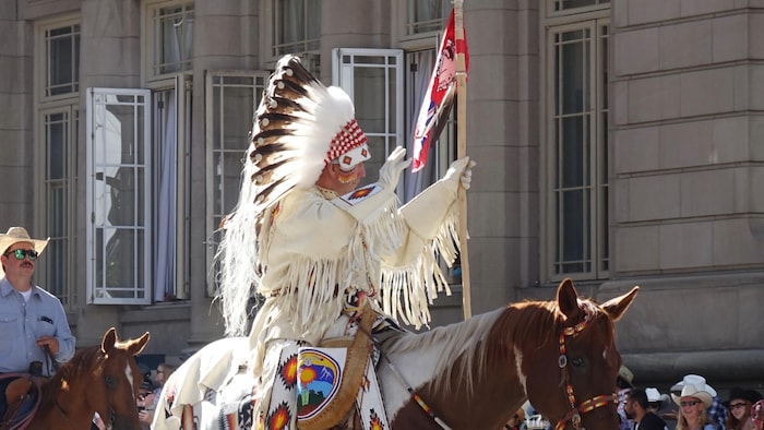 Un cavalier est vêtu d'un costume traditionnel de la nation Stoney Nakoda.