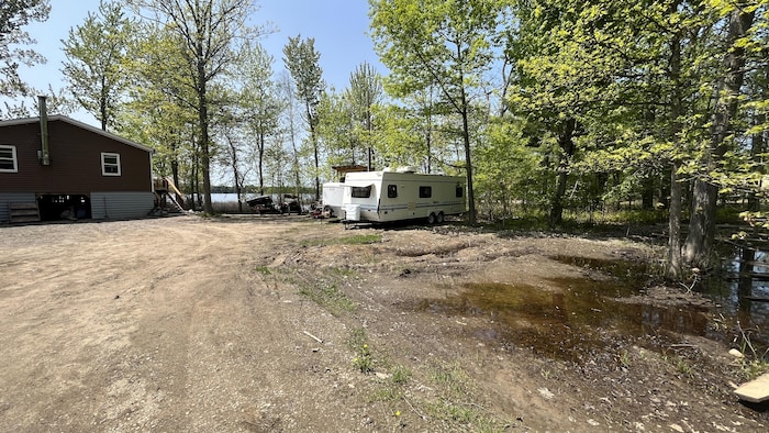 Une roulotte stationnée près d'un chalet.