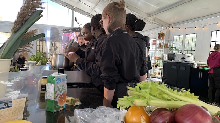 Un groupe de jeunes cuisine une recette. 