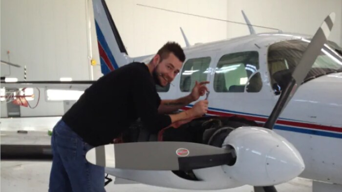 Un homme répare un avion de petite taille.