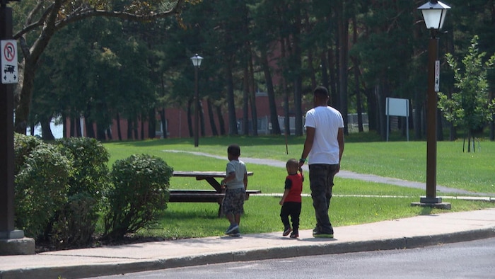 رجل مع طفلين في إحدى الحدائق العامة.