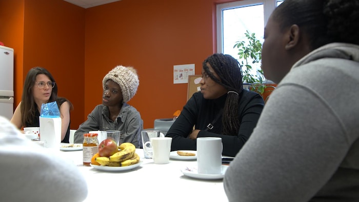 Géraldine Bertrand and other asylum seekers discuss with perinatal care workers at the Centre de pédiatrie sociale de Saint-Laurent. (Patrick André Perron/Radio-Canada)