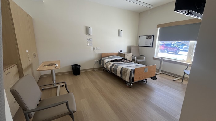 Une grande chambre d'un foyer de soin encore en grande partie vide.