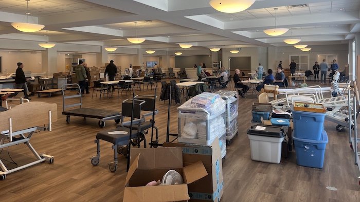 Des boîtes remplies d'affaires sur le sol d'une grande salle.