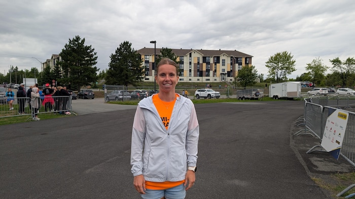 Josyane Tessier souriant sur la piste d'athlétisme de Rouyn-Noranda juste après le départ pour le 10 km.