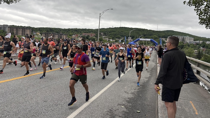 Des centaines de coureurs sont sur la ligne de départ.