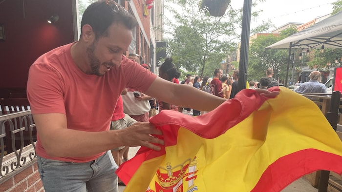 Un homme agite un drapeau de l'Espagne.