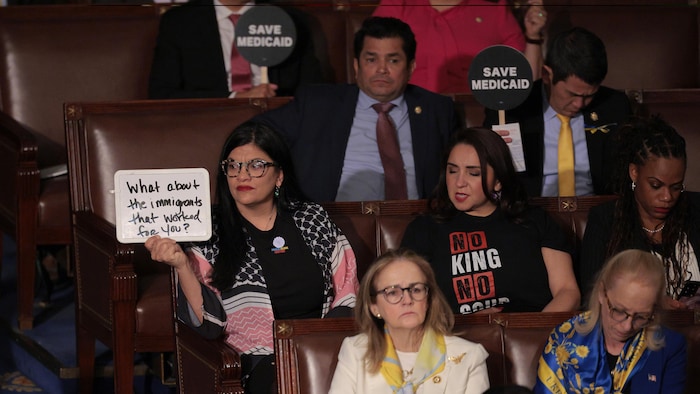 Des démocrates montrent des pancartes qui indiquent leur revendication ou font part de leur protestaion lors du discours de Donald Trump devant le Congrès.